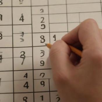 A close-up of a partly filled Sudoku grid